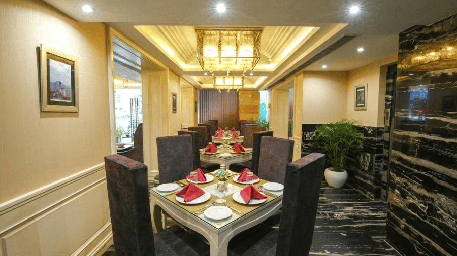 A sophisticated dining corner featuring striking black marble floors, warm gold-accented lighting, and intimate table arrangements - Flute Boutique By Hotel 91, Jaipur