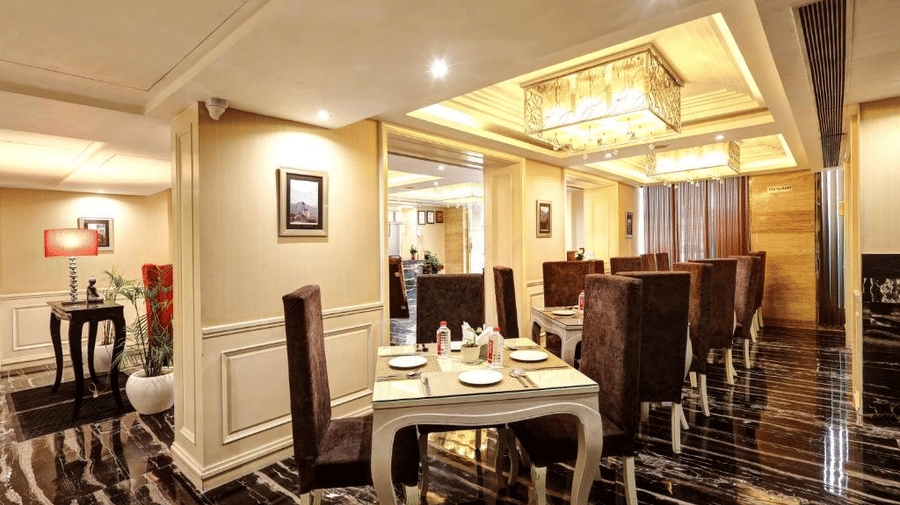 A luxurious view of the dining area highlighting white panelled walls, elegant dark furniture, and a high-end contemporary aesthetic - Flute Boutique By Hotel 91, Jaipur