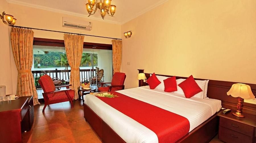  Spacious bed with neatly arranged cushions, complemented by a balcony with two pathways and a sofa arranged nearby to enjoy the view