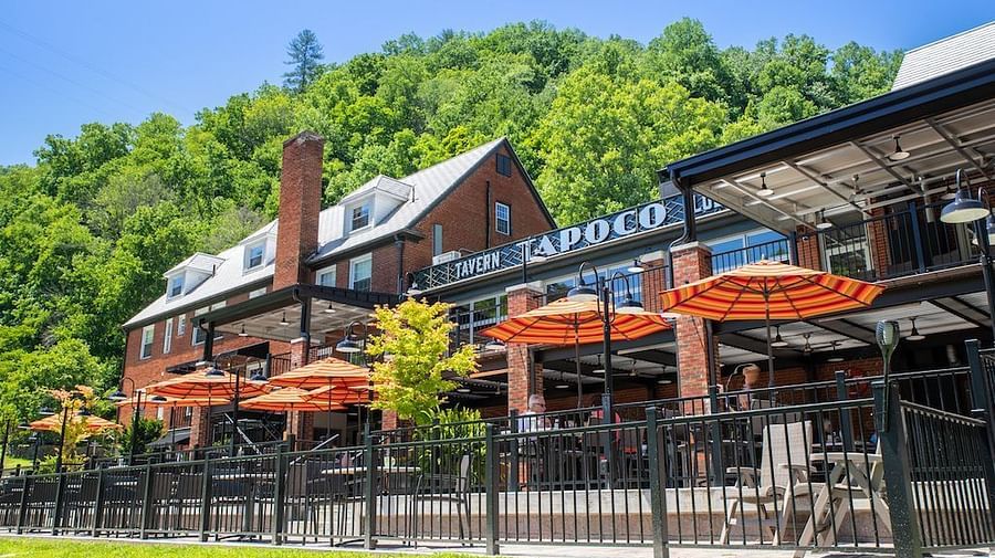 a bright facade image of the Historic Tapoco Lodge taken from a lower angle with a bright clear blue sky in the background - Historic Tapoco Lodge
