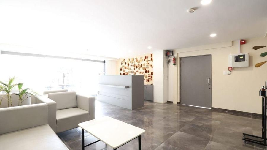 A full-view shot of the neatly-kept lobby area at Pravasa Stay, Ahmedabad (Alba Premier), with ample of natural light coming from the entrance.