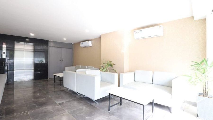 The common seating area at Pravasa Stay, Ahmedabad (Alba Premier), with plush white-coloured couch set.