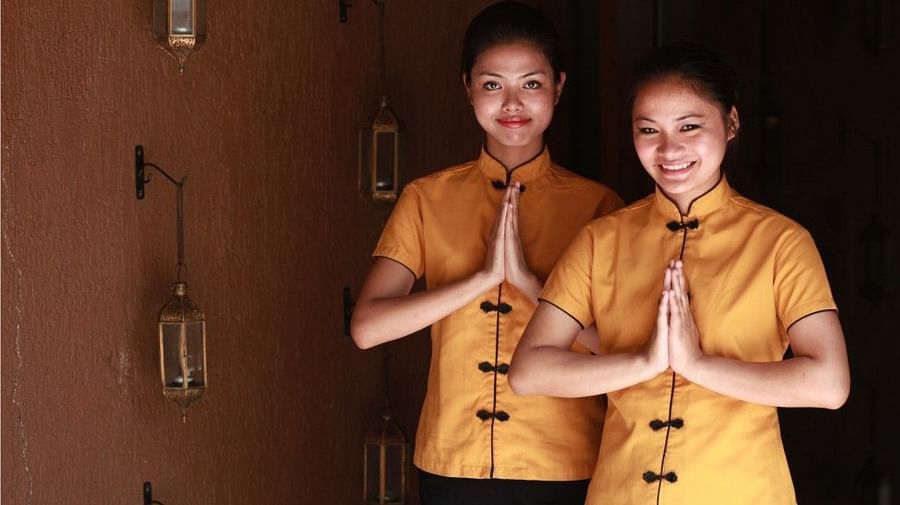 an image of a Women in yellow uniform welcoming their guests - Rhythm Lonavala