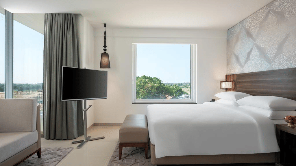 Suite Room with a plush bed and television at The Residency Towers Rameswaram