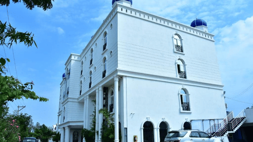White colonial-style hotel building with purple domes.
