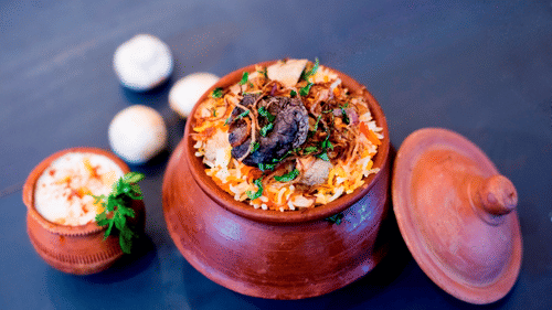 a biryani inside a pot with raitha inside another pot kept in the pot - VITS Sharanam, Thane