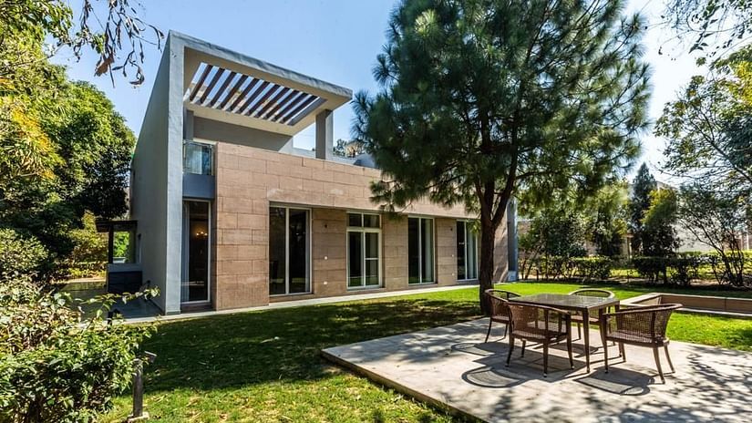 Facade of the Pinewood Villa with a tree in front of it and a garden as well - Karma Lakelands