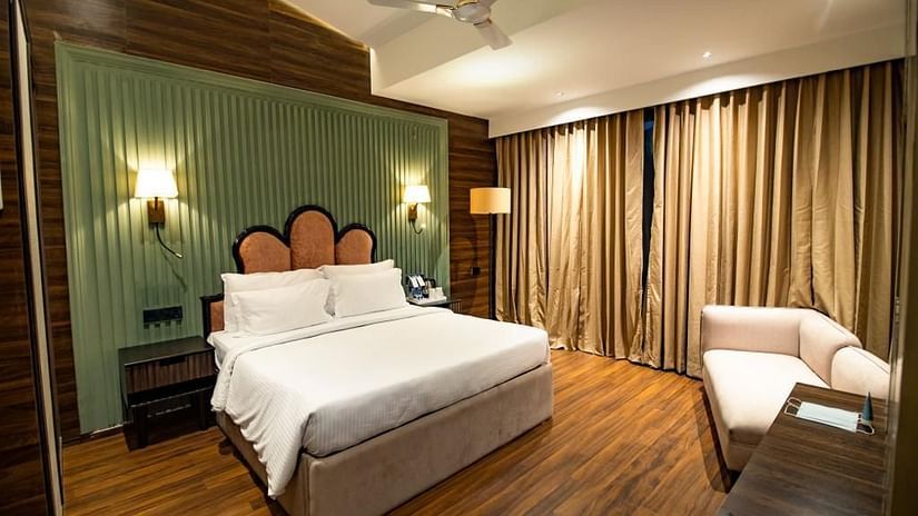 Luxury villa room with a cosy, spacious bed and a sofa in the corner at Wedlock Greens Hotel & Resort, Dhanbad