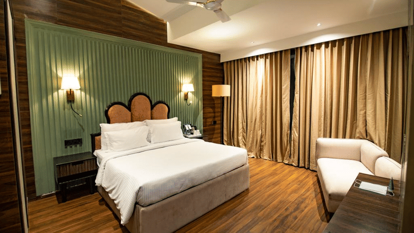 Luxury villa room with a cosy, spacious bed and a sofa in the corner at Wedlock Greens Hotel & Resort, Dhanbad