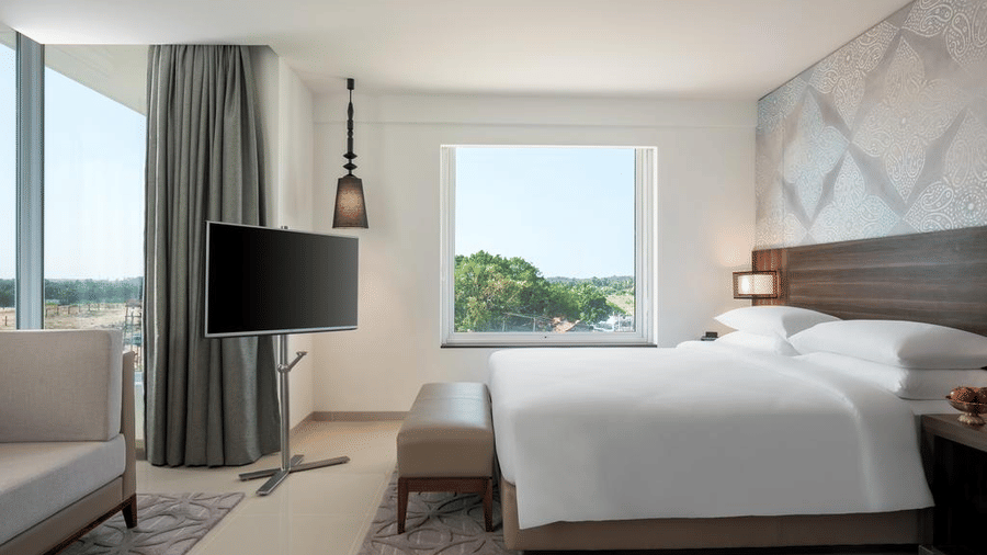 Suite Room with a plush bed and television at The Residency Towers Rameswaram