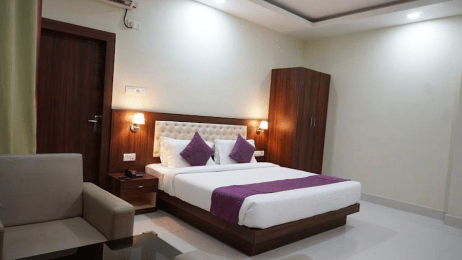 A neat and modern room with double bed, minimalist decor, soft lighting, and a warm welcoming vibe at Pemaling Lords Eco Inn Guwahati.
