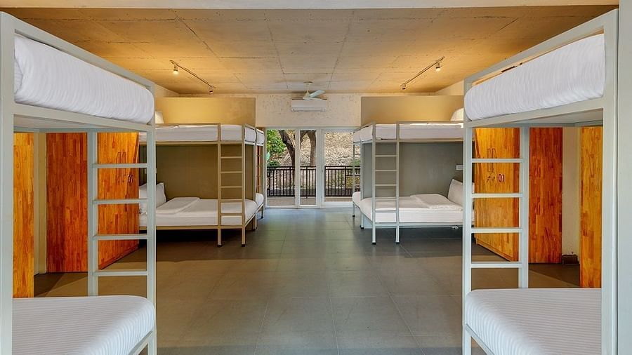 Dorm room with bunk beds and luggage storage.
