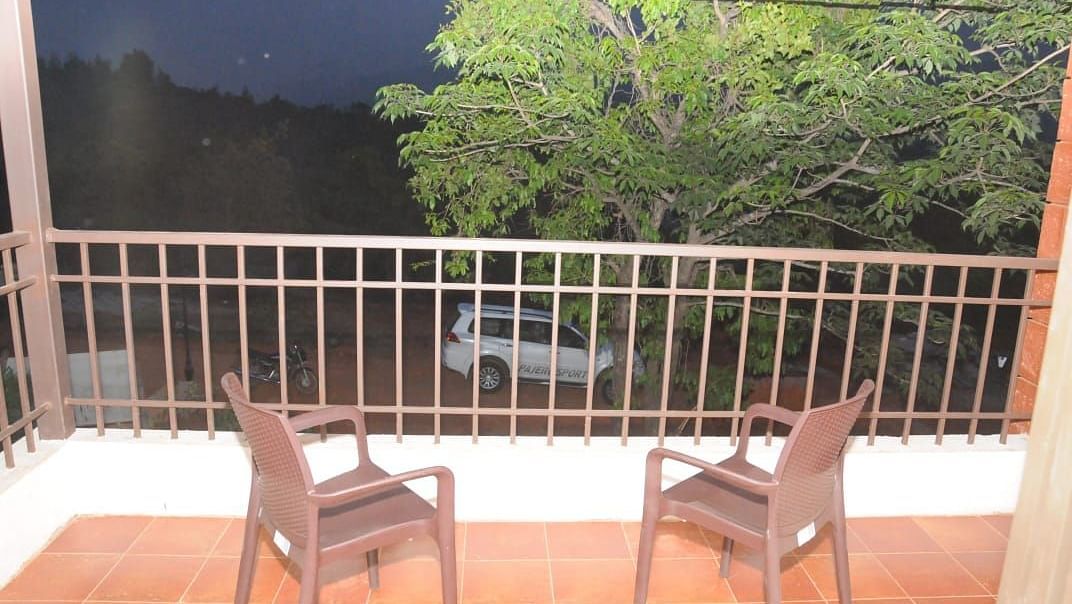 he foreground shows a balcony or patio space with a tiled floor, likely terracotta or a similar material.