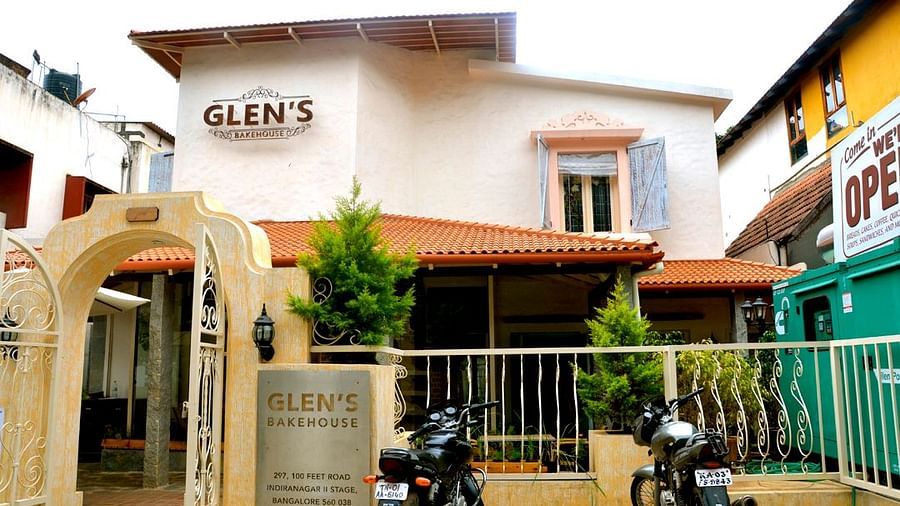 Exterior view of Glen’s Bakehouse café with warm lighting and rustic charm, surrounded by greenery.