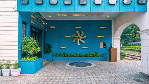 Another angle of the hotel's entrance during the day with a focus on the blue facade and the nautical-themed propeller decoration. - Polo Floatel