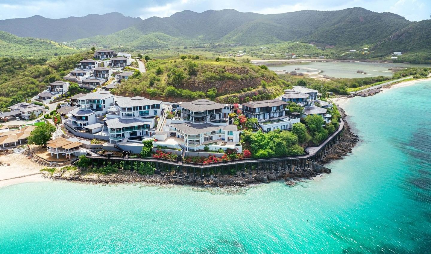 Aerial view of Tamarind Hills Resort and Villas in Antigua, perched on a scenic peninsula with turquoise waters, sandy beaches, and lush green hills.