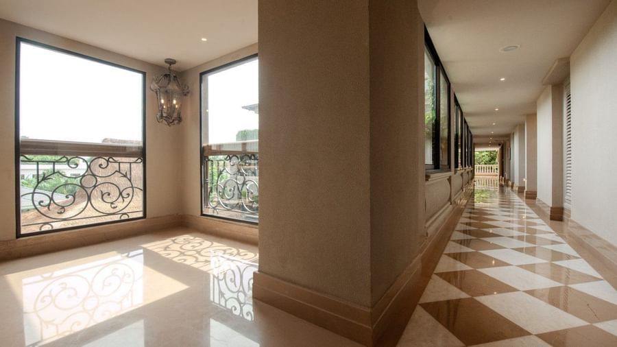 An expansive brightly-lit corridor featuring chequered tiles and huge windows allowing ample of natural light into the corridor at The Evren, Vagator.