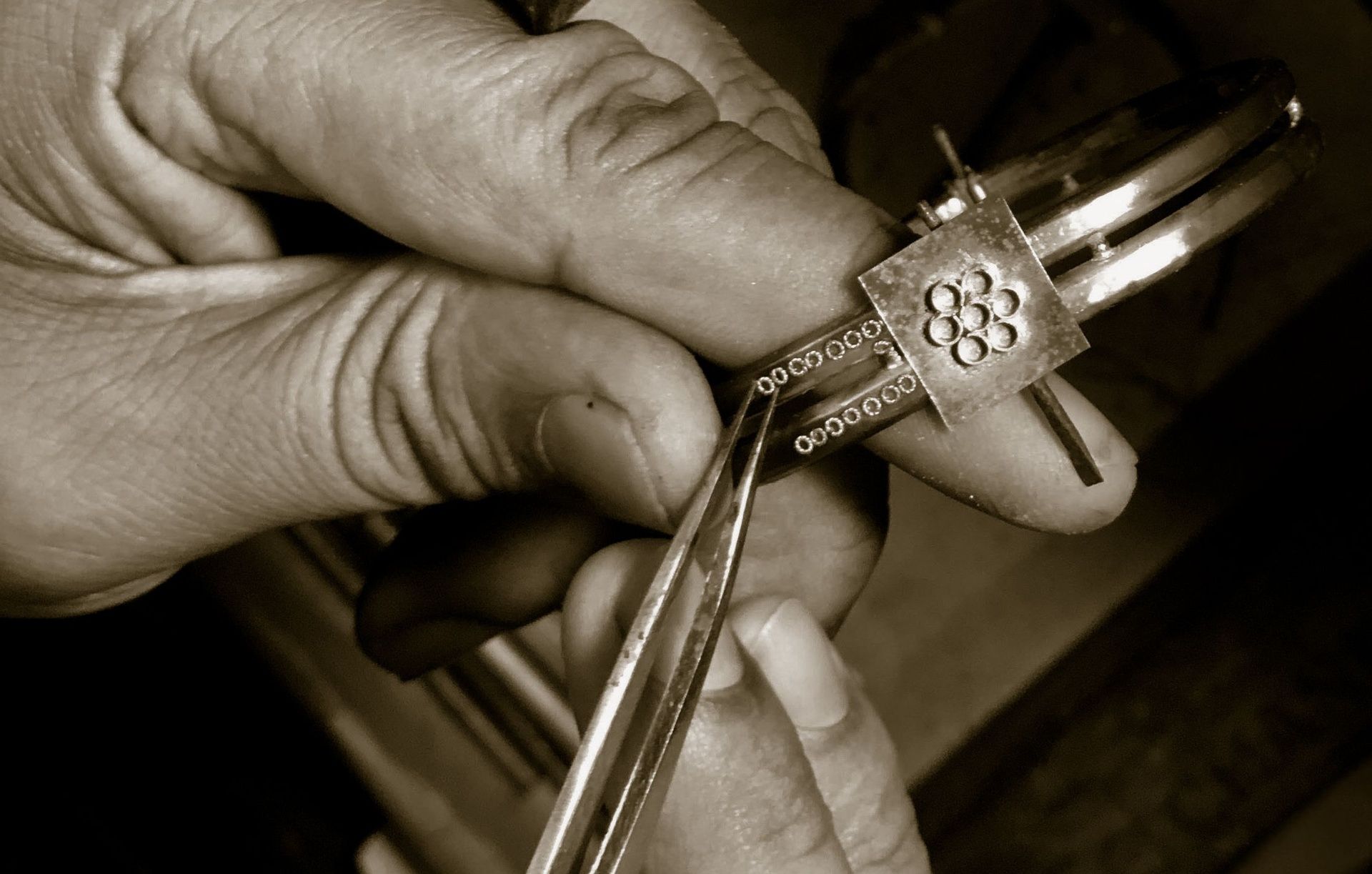Hands crafting intricate geometric pattern on kadaga.