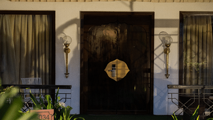 Image of the entrance of an accommodation with a door and windows on the side at Rajasthali Resort & Spa Jaipur.