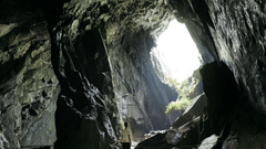 image of a man standing inside a cave with plenty of natural sun light falling inside it