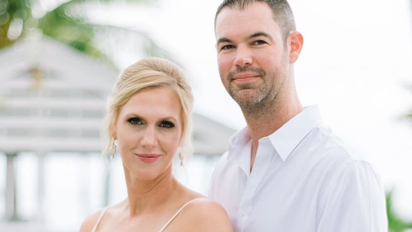 A newlywed couple, featuring the woman holding a white bouquet, posing in the open lawns at Casa Morada.