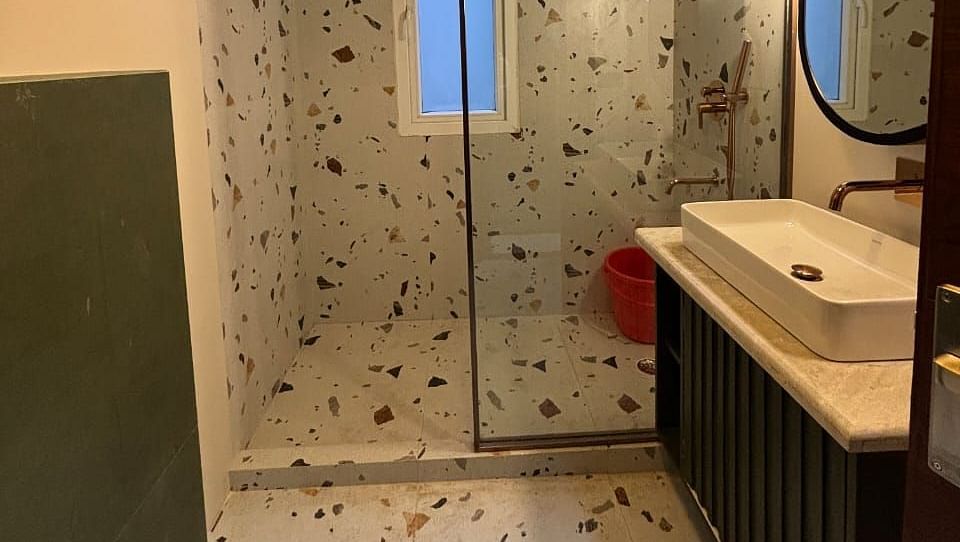 A modern bathroom with a shower, washbasin, and a yellow light fixture - Asian Suites IFFCO Metro, Gurgaon
