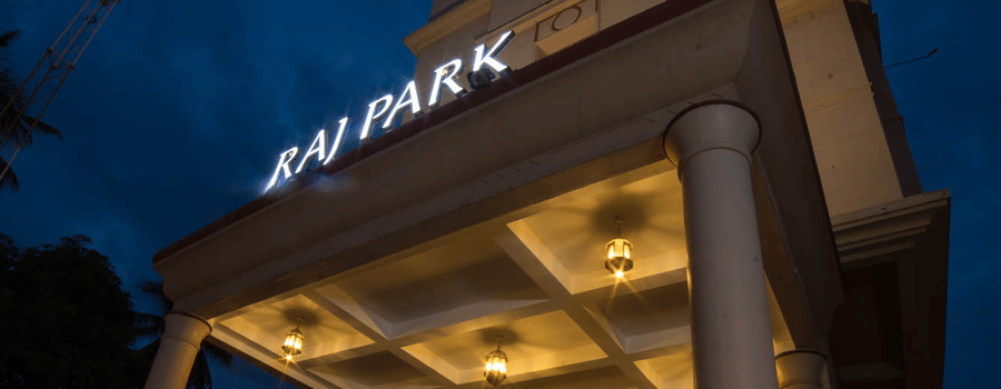 Facade of Hotel raj Park, chennai with dark sky in the backdrop.