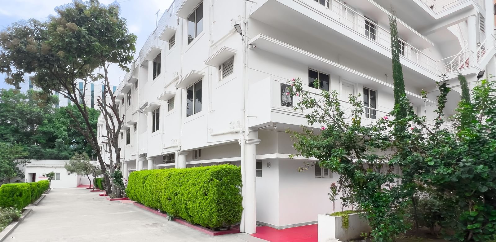 Front view of residential building with pathway and plants at The Pinnacle, Electronic City.
