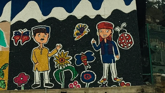 Artwork about the mountains featured on a board next to a building - The Orchid Hotel Shimla
