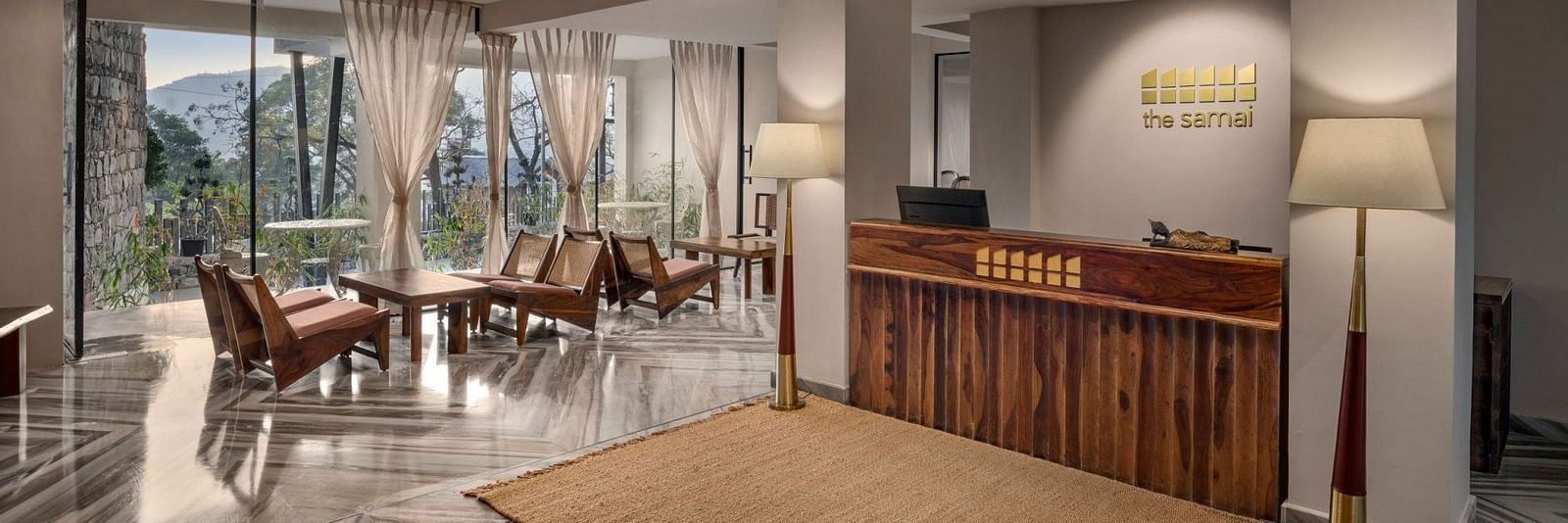 A reception area with a reception desk and comfortable furniture to sit and relax - The Samai, Bhimtal