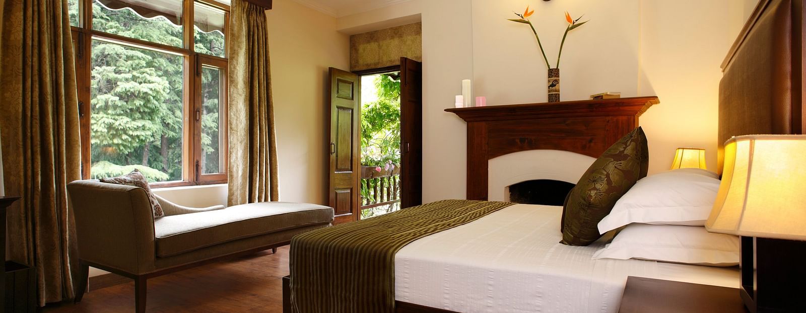 Deluxe room featuring a cozy bed and a view of lush greenery from the window.