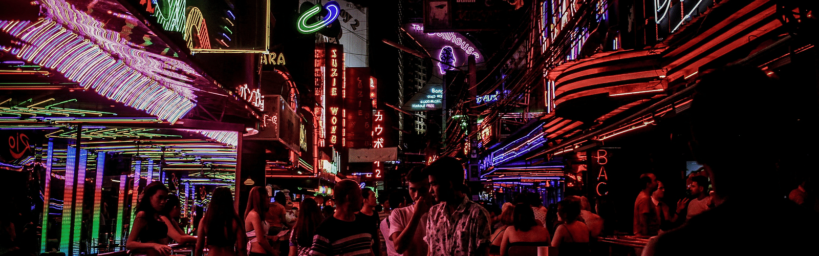 people walking on a street with led lights on buildings