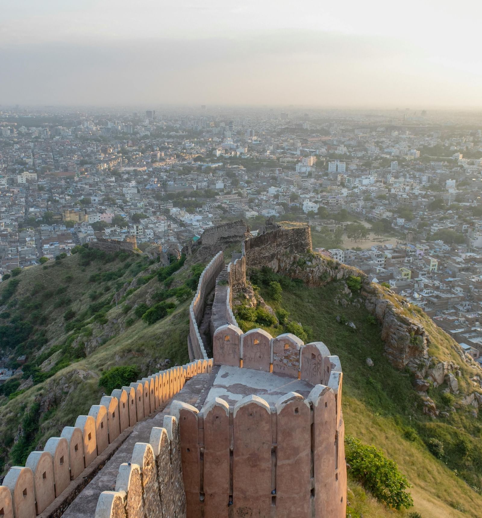 Ancient fort wall snakes across a hilltop, overlooking a sprawling city