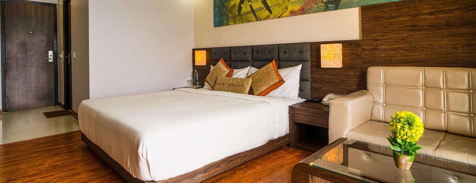 A room with a bed, a sofa, and a coffee table at Mansha Hotel Regency.