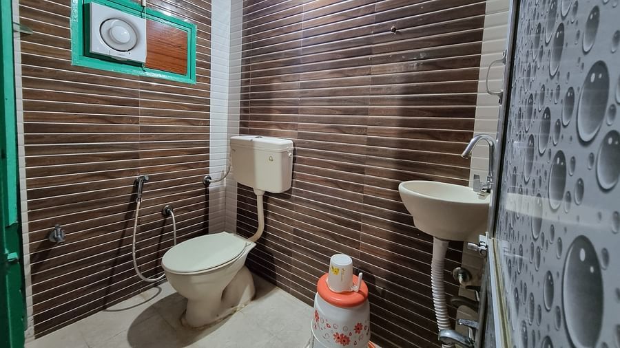 Corner view shot of a bathroom featuring a commode along with a wash basin at the Dream Vision Guest House.