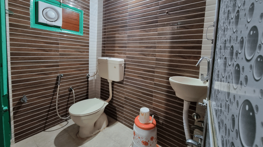 A bathroom featuring a commode along with a wash basin in a Standard Double Bed Non A/C Room (No TV) at Dream Vision Guest House, Diu.