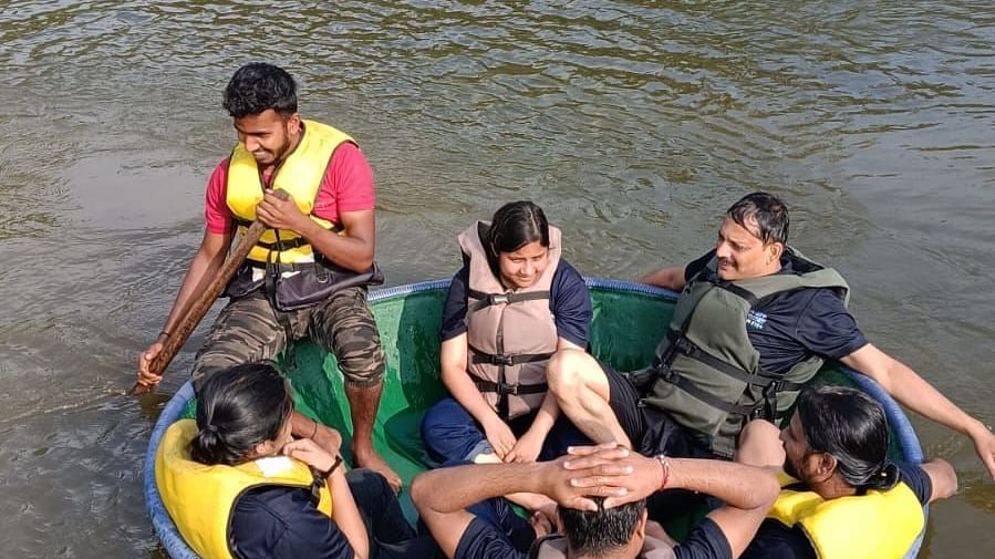 Group of adults and children enjoying a coracle ride on a river surrounded by lush greenery - Evergreen County