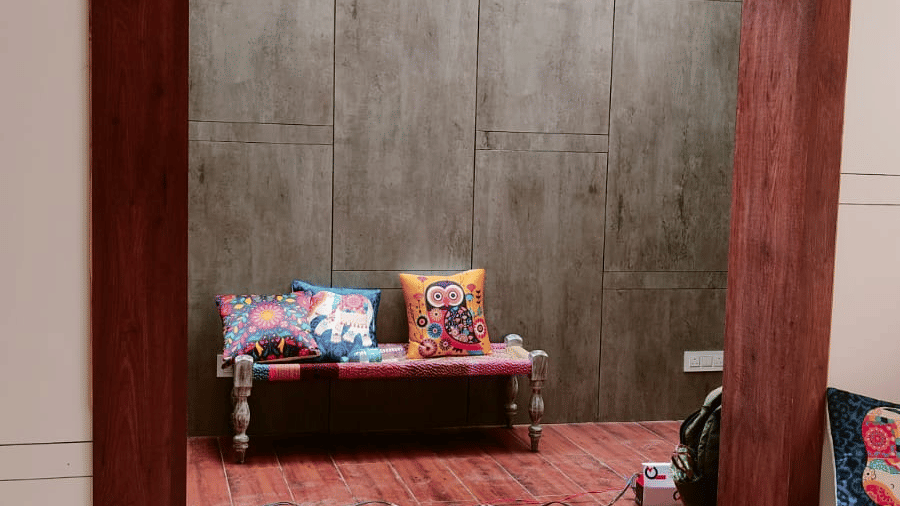 A wooden archway leading to an interior room with a red carpet and a glimpse of furniture - Hotel Dolphin Puri