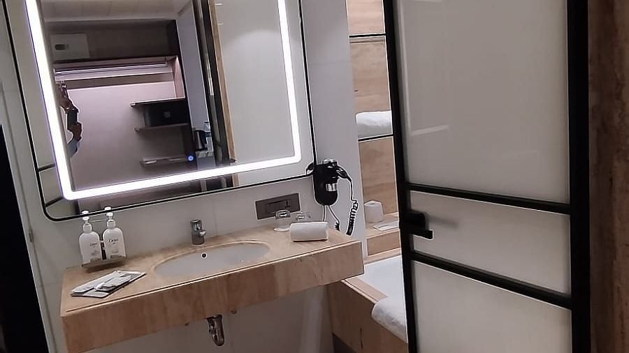 A view from the doorway of a well-lit bathroom in an executive room at Mirage Hotel, featuring the sink area and an illuminated mirror.