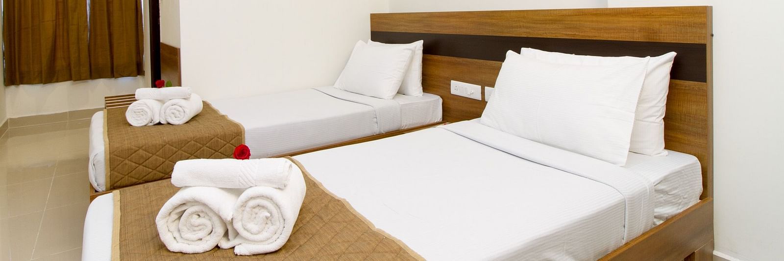 A room at Sanctum Suites Whitefield, Bangalore offering two single beds and a small seating area.