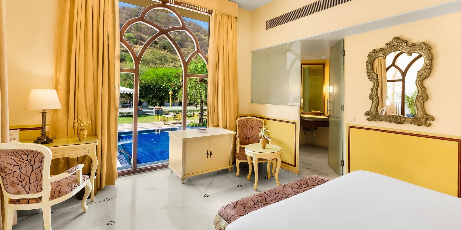 Charming room with private balcony and work desk at Rajasthali Resort Jaipur, blending comfort with heritage elegance.