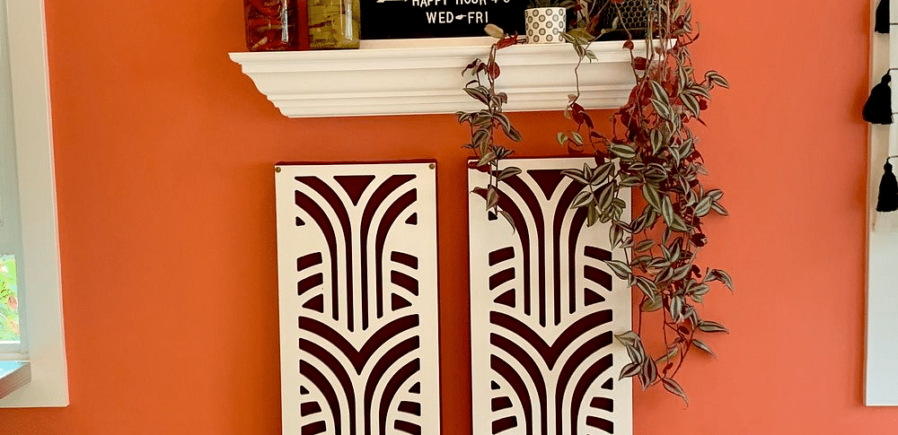 A wall with a framed menu, a shelf with items, and two patterned panels, with a stool and chair visible.