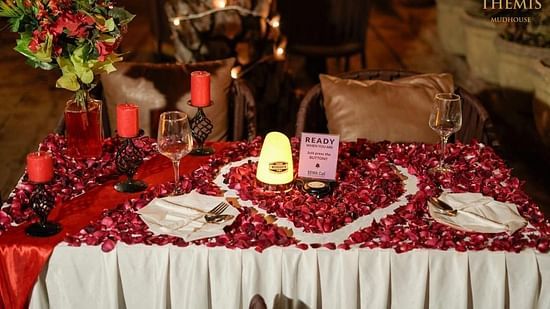 Candle light dinner with a rose petal decoration at themis mudhouse.