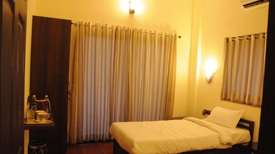 A bedroom with a single bed, wardrobe, and warm lighting.