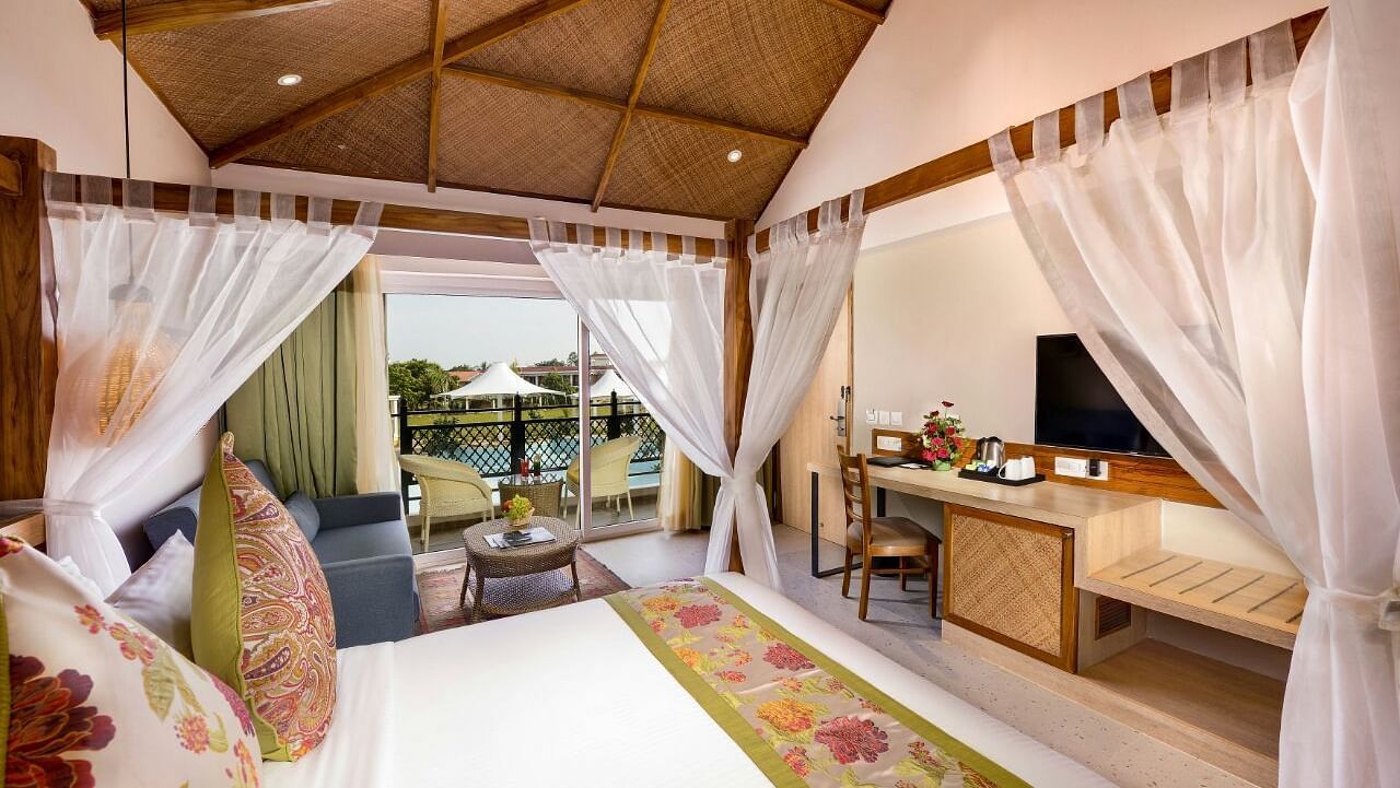 A room at Swosti Chilika Resort with a double bed, work desk and chair and a television 