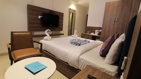 Room at Hotel Mumbai House Express, Udaipur with a double bed, a television and a coffee table and chair