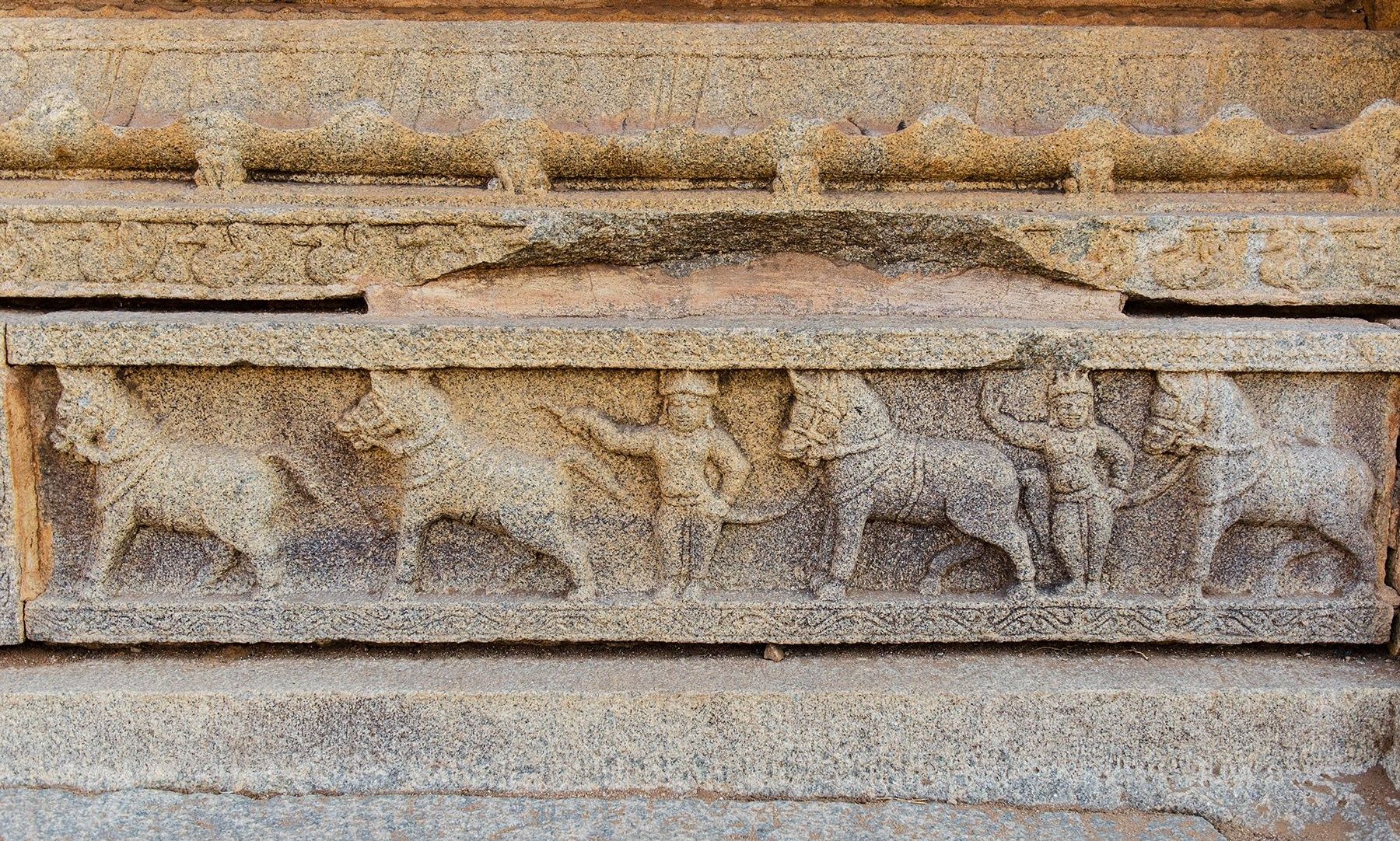 Stone carving of horse traders on a Hampi temple wall.