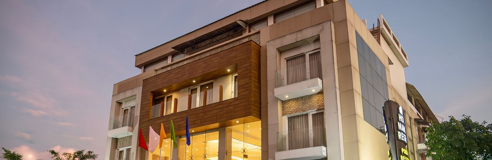 The exterior of Mansha Hotel Regency, a multi-storey building with a modern design, captured during early evening | Mansha Hotels