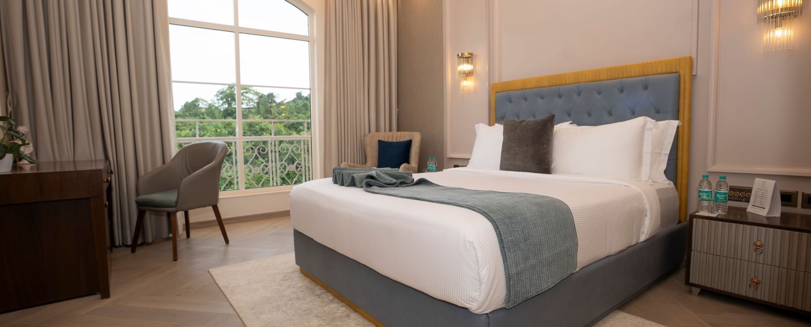 Spacious bedroom with king bed and bright light at Miros Hotels.