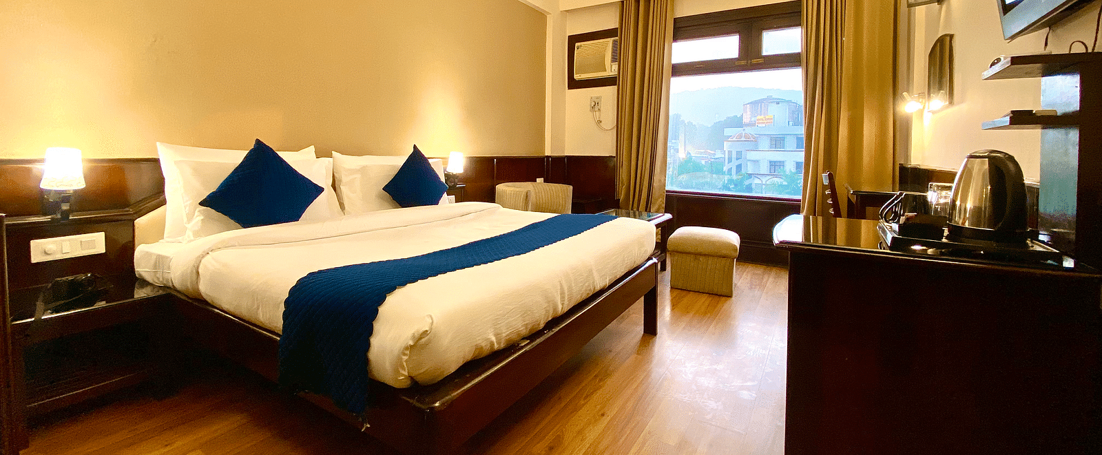 A bedroom with a ceiling fan and windows covered by curtains at DLS Park Grace, Haridwar.